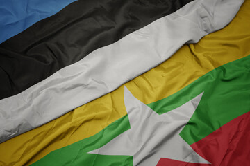 waving colorful flag of myanmar and national flag of estonia.