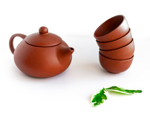 Terracotta teapot and cups on white background