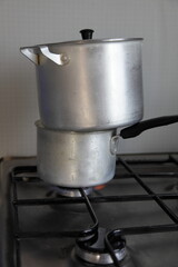 Two aluminum pans are cooked together on the same burner, saving gas when cooking on a gas stove