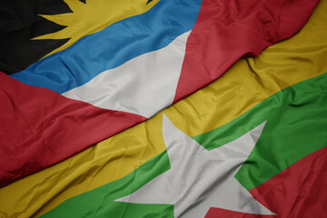 waving colorful flag of myanmar and national flag of antigua and barbuda.