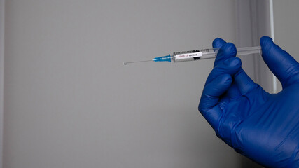 Medical flu shot, covid-19 vaccine. Medicine in a syringe for a viral disease, the doctor holds a...