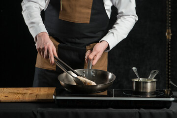 man cooking meat and sauce on a induction cooker