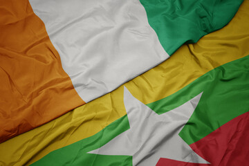 waving colorful flag of myanmar and national flag of cote divoire.