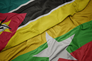 waving colorful flag of myanmar and national flag of mozambique.