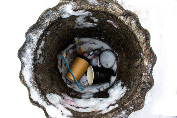 Photo of a trash can and the garbage lying in it.