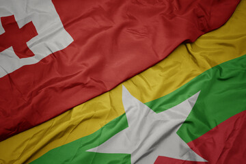 waving colorful flag of myanmar and national flag of Tonga .