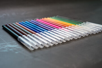 Colorful markers on a dark background. Concept of education, learning, creative and arts and crafts.