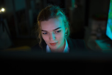 Young business woman office worker working by PC at night
