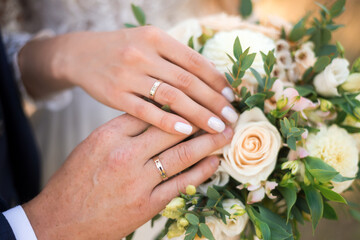 Obraz na płótnie Canvas newlyweds ' hands with rings. Wedding bouquet on the background of the hands of the bride and groom with a gold ring