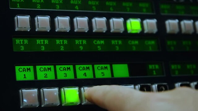 Hand press on the switcher buttons, video switcher of Television Broadcast. Hand of film director is touching key on a control panel during tv shooting