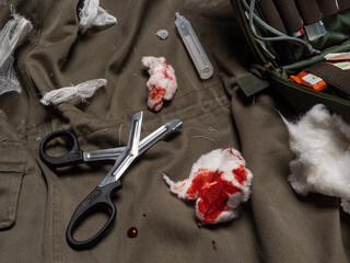 Trauma shears and bloody cotton wool on a tarp