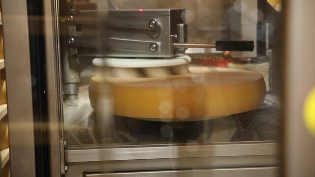 Robot qui nettoie le comt&eacute; qui est en affinage dans une cave. Fromagerie situ&eacute; dans le jura qui utilise une machine pour la fabrication de son fromage.