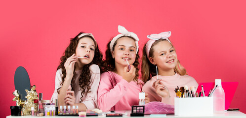 Cosmetics shop. Happy girls doing makeup. Sisters play with cosmetics. Cosmetics for children. Spa...