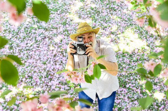 Grandfather photographer. Senior man holding professional camera. Vintage camera. Retro camera. Old happy man. Retirement Hobbies. Photography courses. Education for elderly. Power behind picture