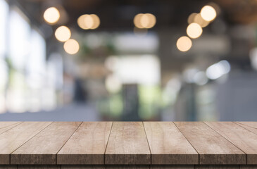 Empty wooden table top with lights bokeh on blur restaurant background.