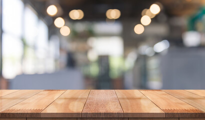 Empty wooden table top with lights bokeh on blur restaurant background.