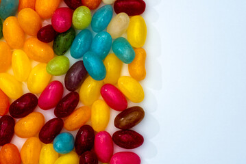 Bright colorful photograph of candy jelly beans shot from above on a white background with copy space