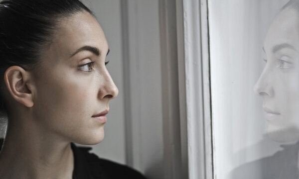 young woman looks out the window