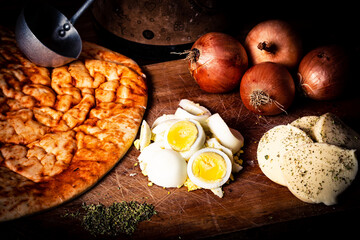 pizza huevos cebollas queso sobre tabla de madera 