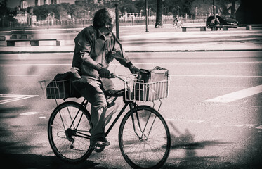 Fototapeta na wymiar hombre con barbijo en bicicleta en blanco y negro