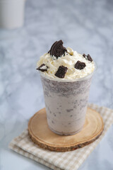 Chocolate cookie smoothie topped on whipping cream in glass plastic.