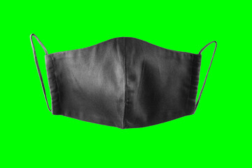 Black face protective mask on a green background. Reusable face mask isolated. Face antivirus mask made from cotton. Isolate