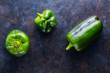Ugly bell pepper on dark background. Deformed homegrown green bell pepper. Concept - reduction of...