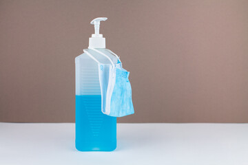 bottle with blue antiseptic on table with background and mask