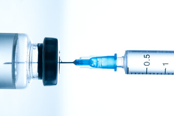 Medical syringe with a needle and a bollte with vaccine.