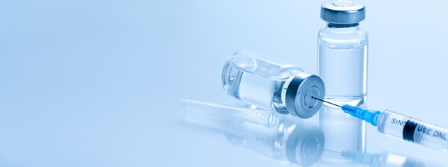 Medical syringe with a needle and a bollte with vaccine.