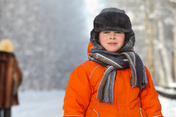 Little boy on a frosty day outdoors during winter holidays.