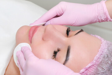 Obraz na płótnie Canvas cosmetology. Close up picture of lovely young woman with closed eyes receiving facial cleansing procedure