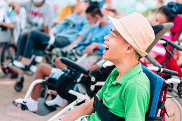 Asian disabled child on wheelchair is playing, learning and exercise in the outdoor park with...