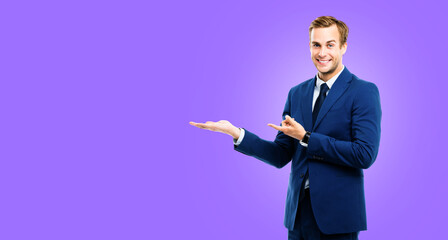 Businessman showing something, isolated over purple violet color background. Copy space for slogan...