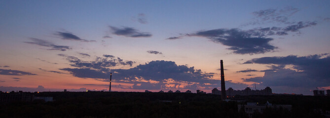 Fototapeta na wymiar evening city landscape. silhouettes of buildings against a cloudy sky. bright colors panorama