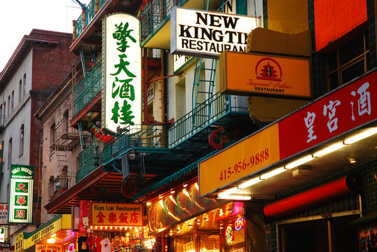 Signs in San Francisco's Chinatown begin to illuminate at dusk 
