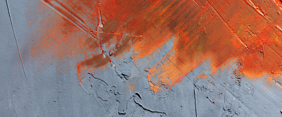 Orange paint smeared across a rough, uneven wall