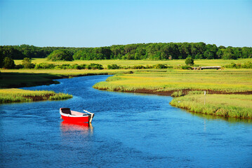 A e red canoe sites in a calm marsh