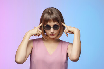 stylish girl in sunglasses. photo shoot in the studio on a pink background