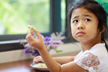 A Lovely Little Asian Girl Happy to Eating Homemade Cookies made at House.