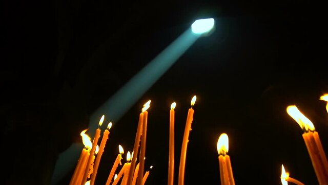 Prayer in the church, candles lit, slow motion, church wedding ceremony, wedding in ortodox church, close up of candles, blurred background
