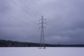 Linia elektryczna pośród pokrytych śniegiem pól. - obrazy, fototapety, plakaty