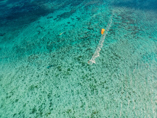 Kitesurfer and windsurfer in tropical blue sea at Mauritius. Aerial view.