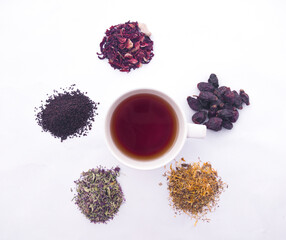 Obraz na płótnie Canvas A mug of tea and an assortment of dried herbs and berries