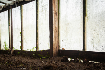 Empty homemade greenhouse in the village in winter without vegetables 