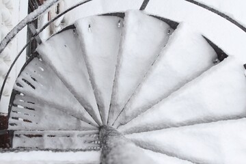 Fire stairs, spiral staircase in North America in January during a blizzard and snow storm.