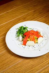 Vegetable vegetarian salad with tomatoes, peppers and onions on wooden table.