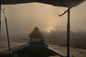 Fototapeta na wymiar Navigating the Tambopata River at sunrise, Tambopata National Reserve, Peruvian Amazon