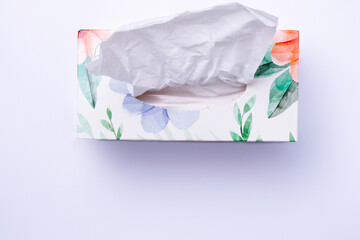 Colored box with disposable paper napkins on white background with bottom blank space.