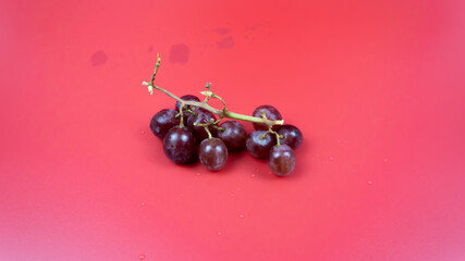Fresh red grapes in a bowl isolated on pink background. Selective focus on the fresh red grapes.